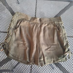 olive green shorts with gold accents and tassels